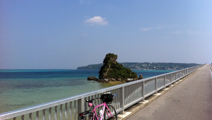 Cycling over the beautiful blue ocean on the long bridge to Kourijima island in Okinawa, Japan